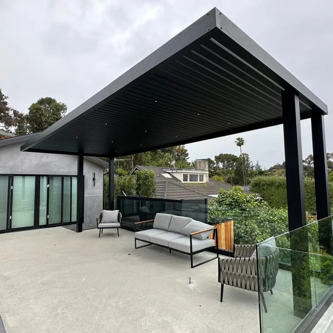 Custom black aluminum patio cover with insulated roof panels, recessed lights, heater, and ceiling fan