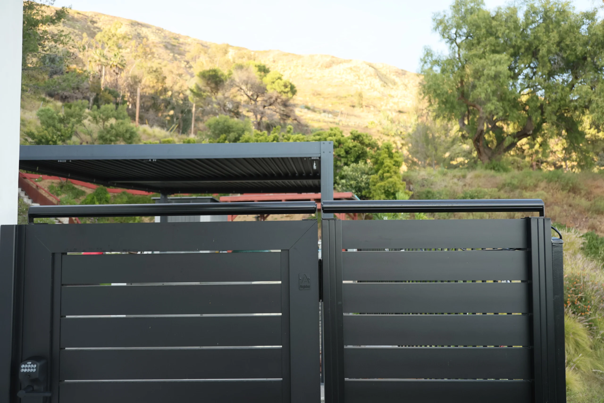 Coyote roller installed over black aluminum gate