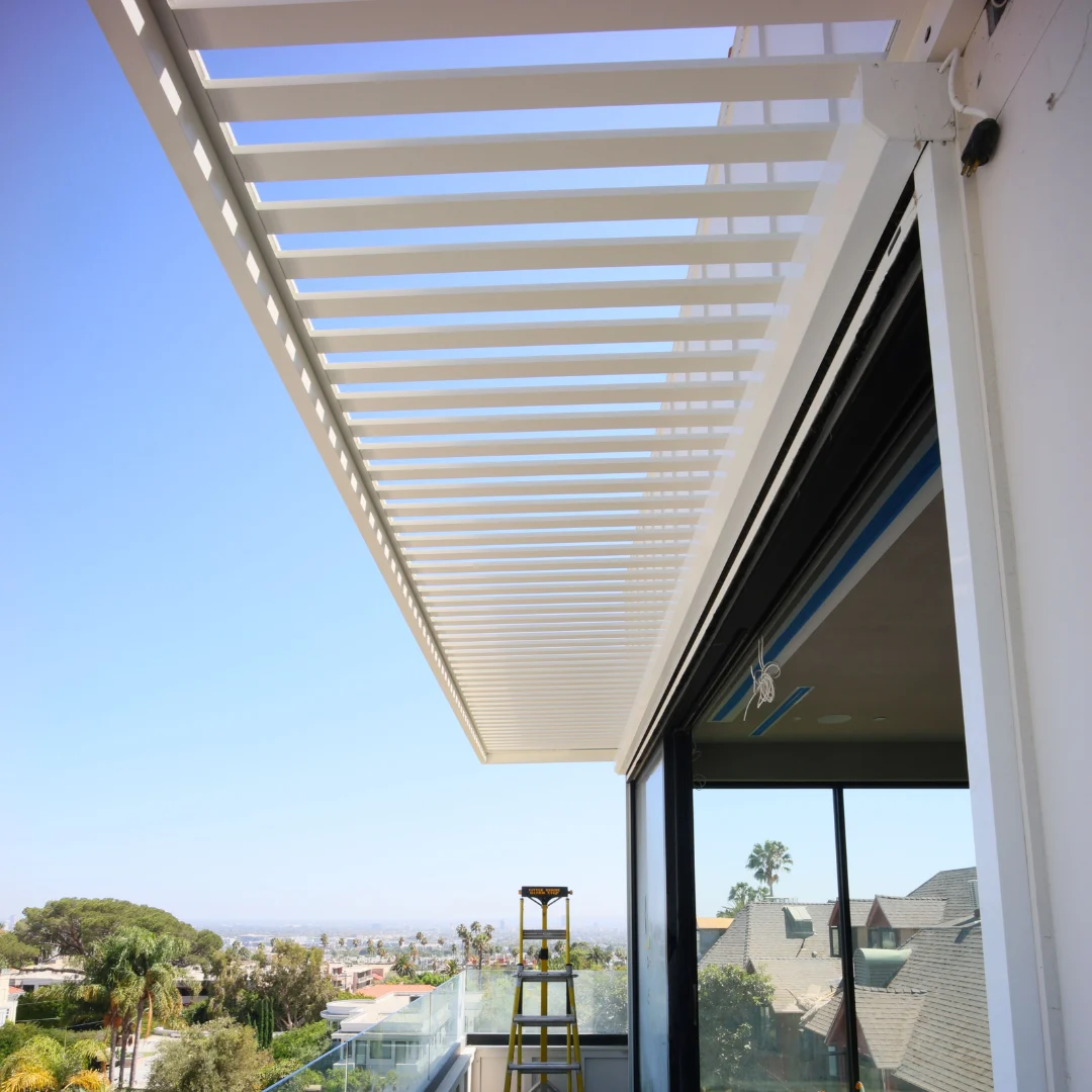 White wall-mounted louver shade canopy overlooking a residential city view
