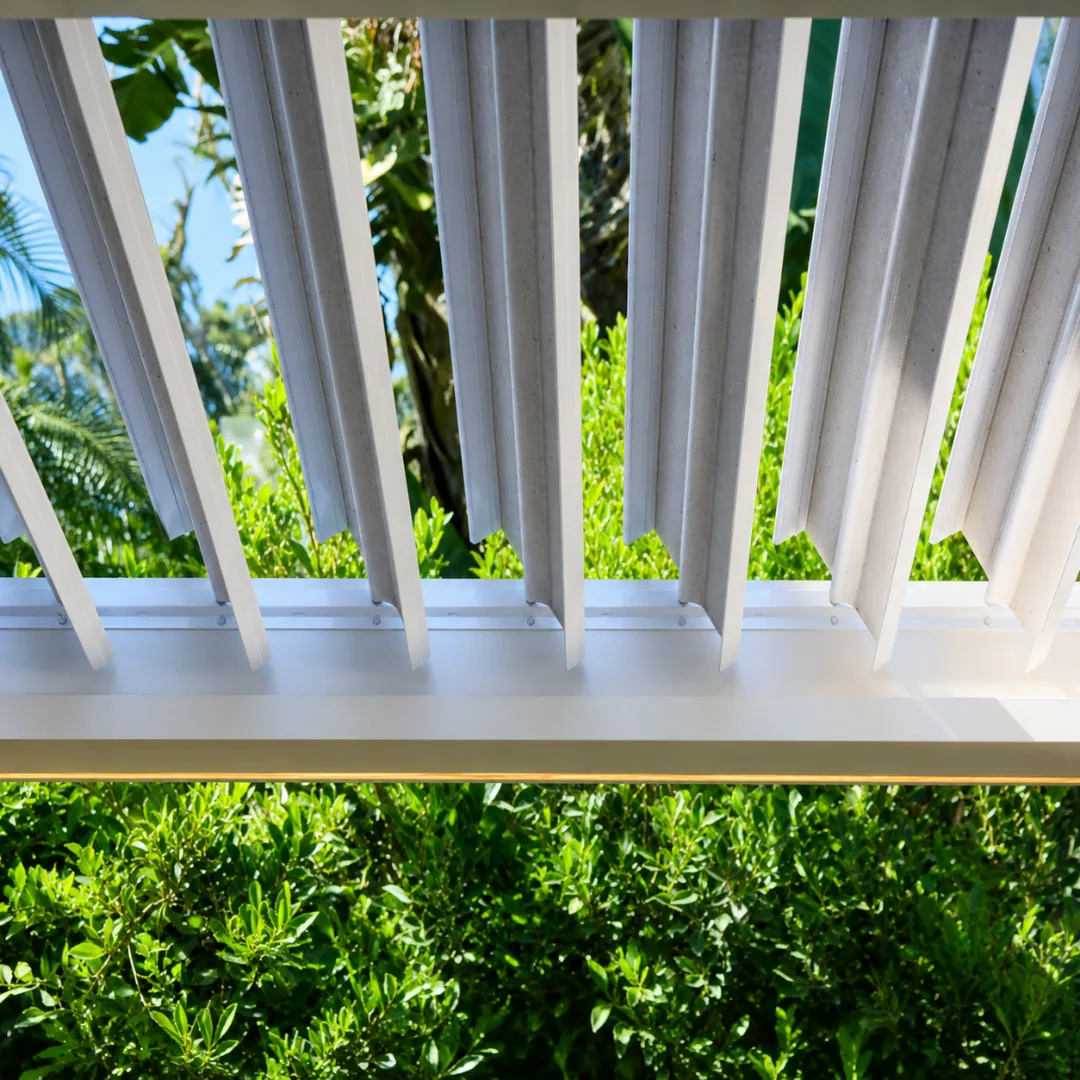 Close-up of white rotating aluminum louver blades in an open position