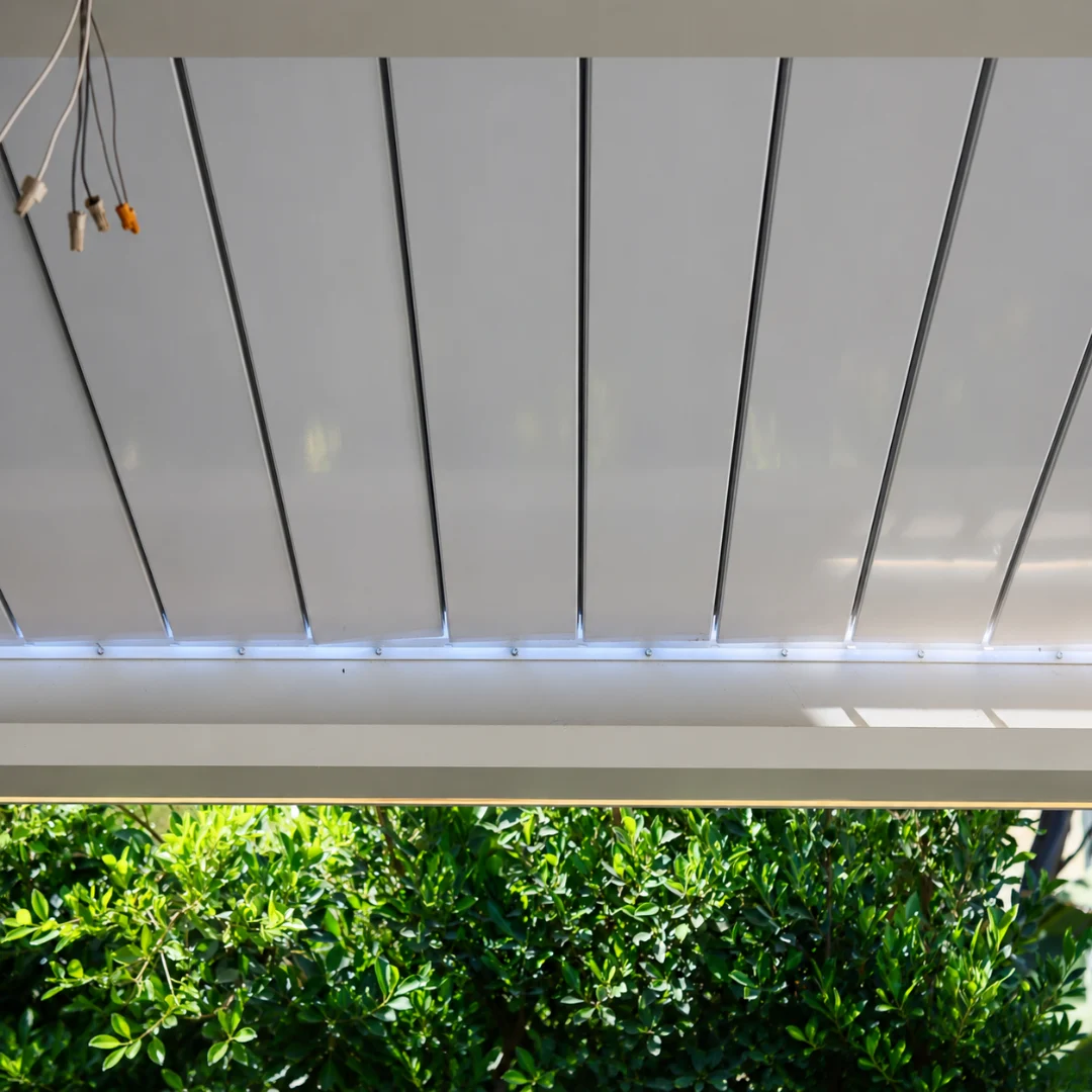 Close-up underside view of a fully closed white louver roof