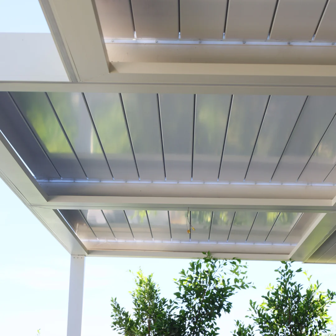 Multi-zone white automatic louver roof closed above a residential patio