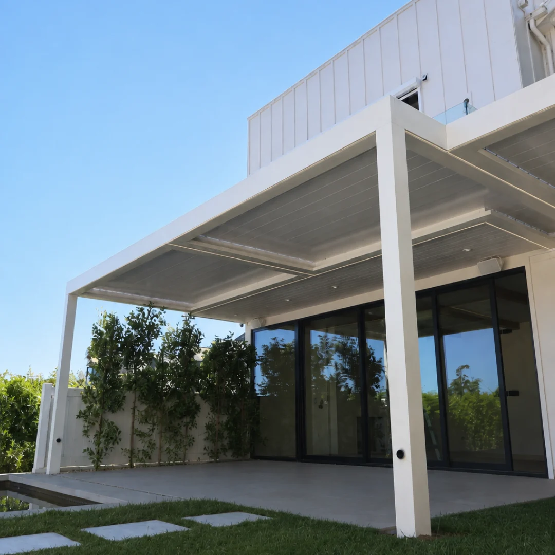 White automatic louver patio cover closed over a modern backyard patio