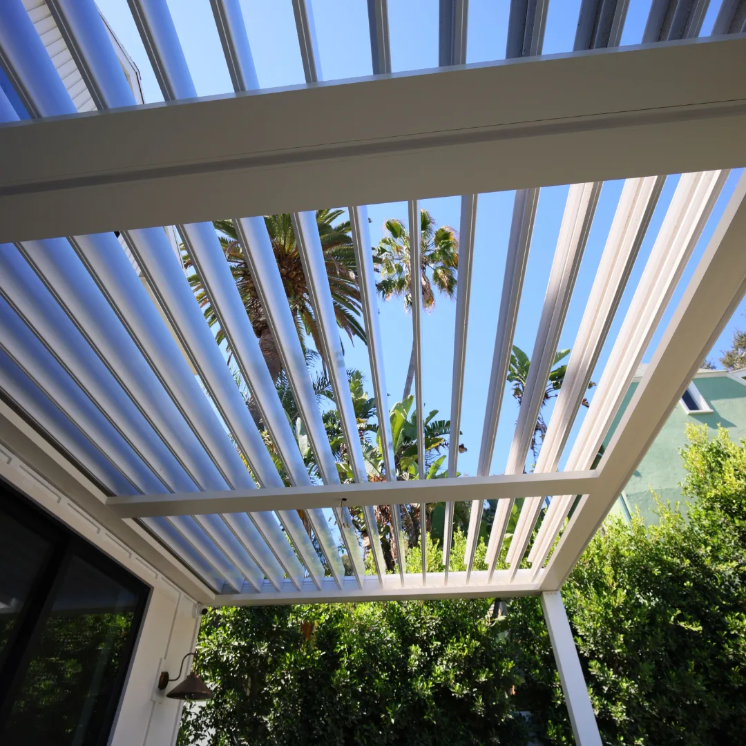 Open white aluminum louver blades viewed from beneath the patio cover