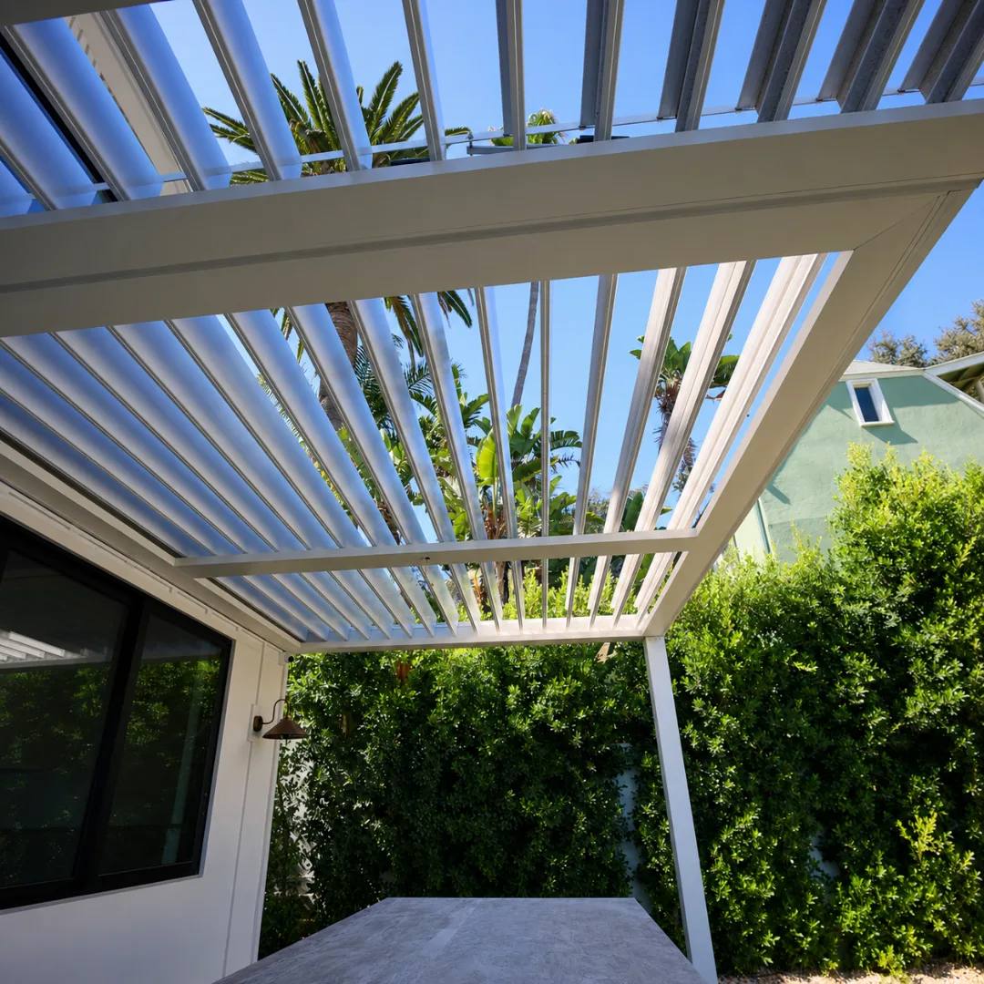 White motorized louver patio cover open above a residential patio