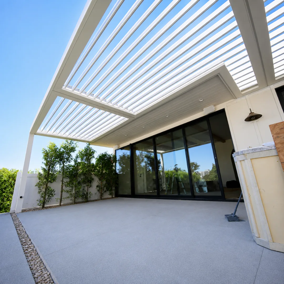 White motorized louver pergola with open blades beside a modern home