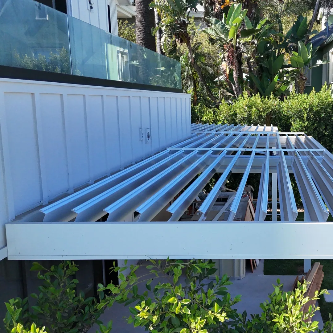White automatic louver patio cover installation with open aluminum blades