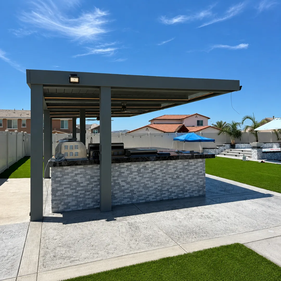 Gray automatic louver pergola above a backyard outdoor kitchen