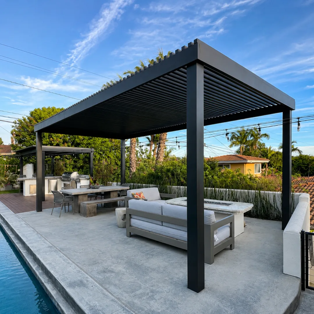 Freestanding black aluminum slat patio cover shading a poolside seating and dining area