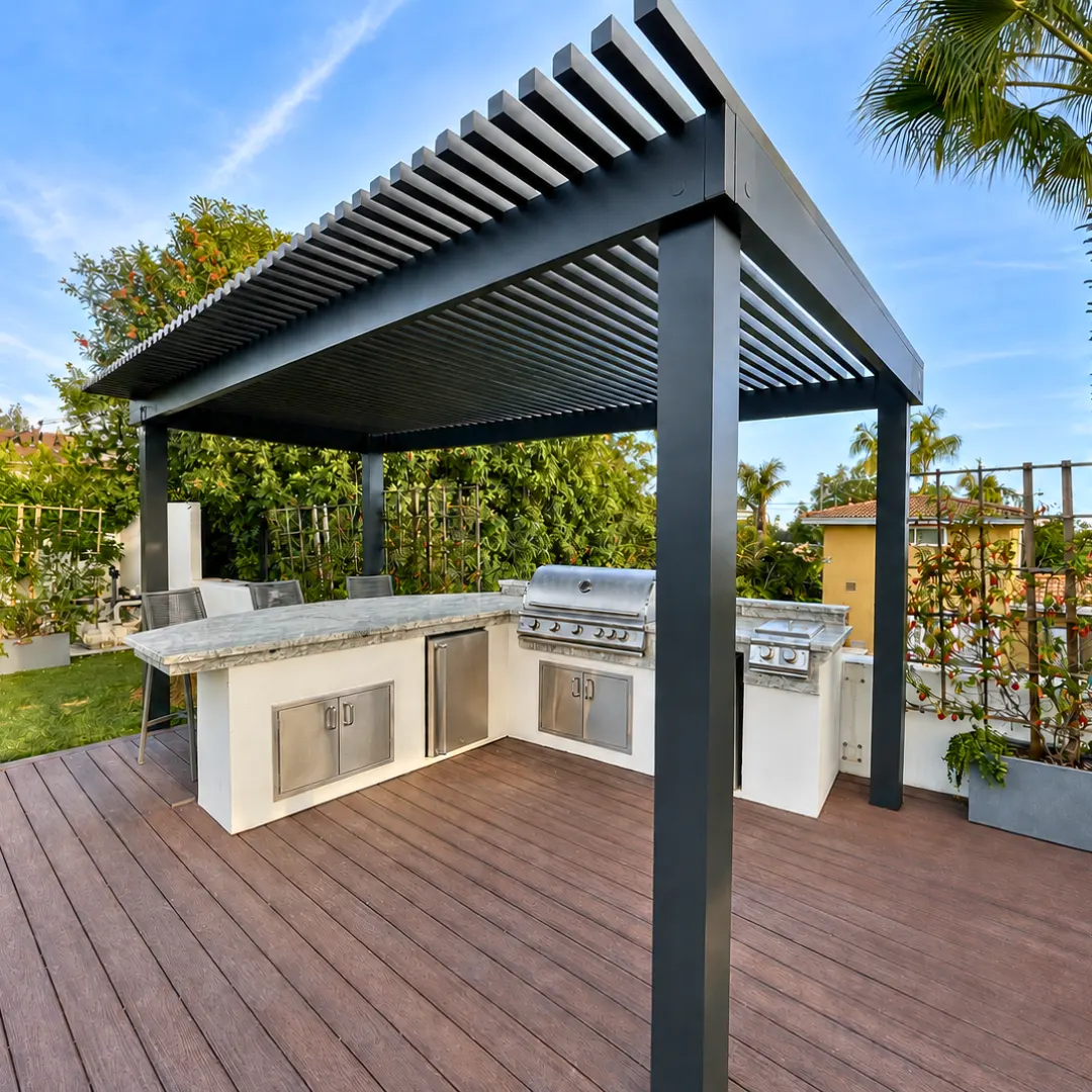 Black aluminum slat patio cover shading an outdoor kitchen and grill on a backyard deck