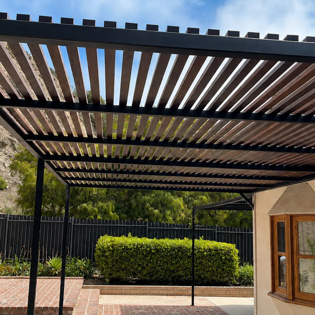 Wood-look aluminum slats set in a black patio cover frame above a brick courtyard