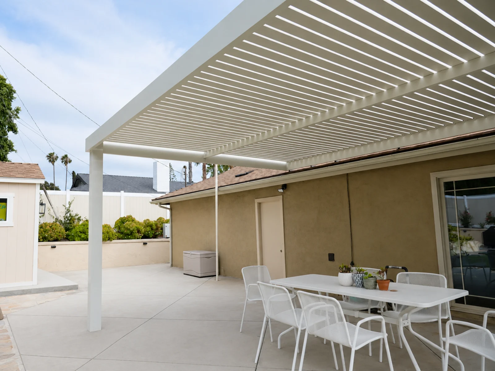 Aluminum pergola with a fixed slat roof over an outdoor living space