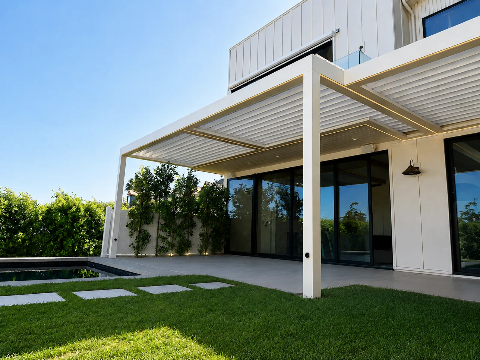 Modern automatic louver patio cover creating adjustable shade over an outdoor living area