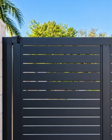 Automated heavy-duty black aluminum sliding driveway gate using the Alu40 slat profile.