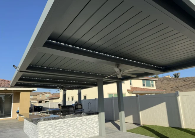 Center beam view of automatic louvered pergola featuring integrated outdoor ceiling fan and recessed LED downlights in Corona, CA.