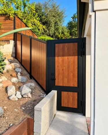 Close-up of smart Bluetooth digital lock handle mounted on Alu60 woodgrain aluminum pedestrian gate.