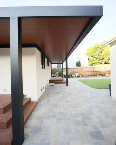 Modern black motorized louvered pergola roof with recessed LED downlights installed above poolside deck