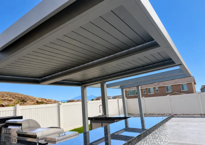 Cantilevered structural aluminum pergola system with open adjustable louvers installed on backyard concrete patio.