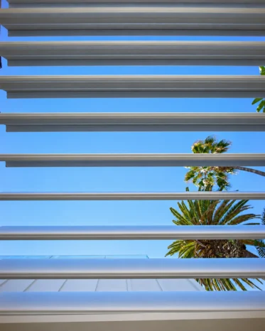 Automatic motorized louvered aluminum patio cover with open roof slats in Los Angeles CA.