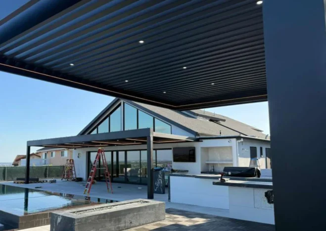 Modern black motorized louvered pergola roof with recessed LED downlights installed above poolside deck