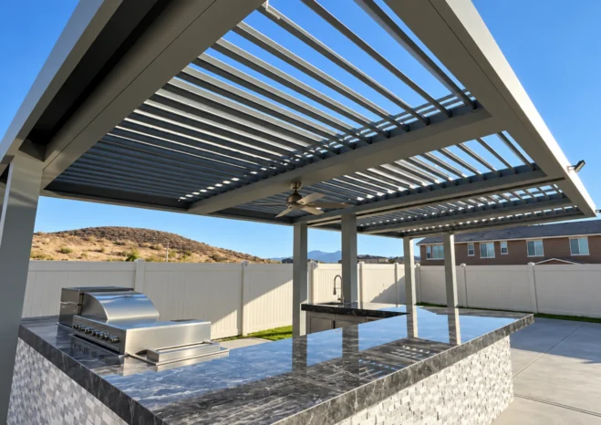 Custom automatic motorized louver patio cover with outdoor ceiling fan over backyard kitchen island in Corona CA
