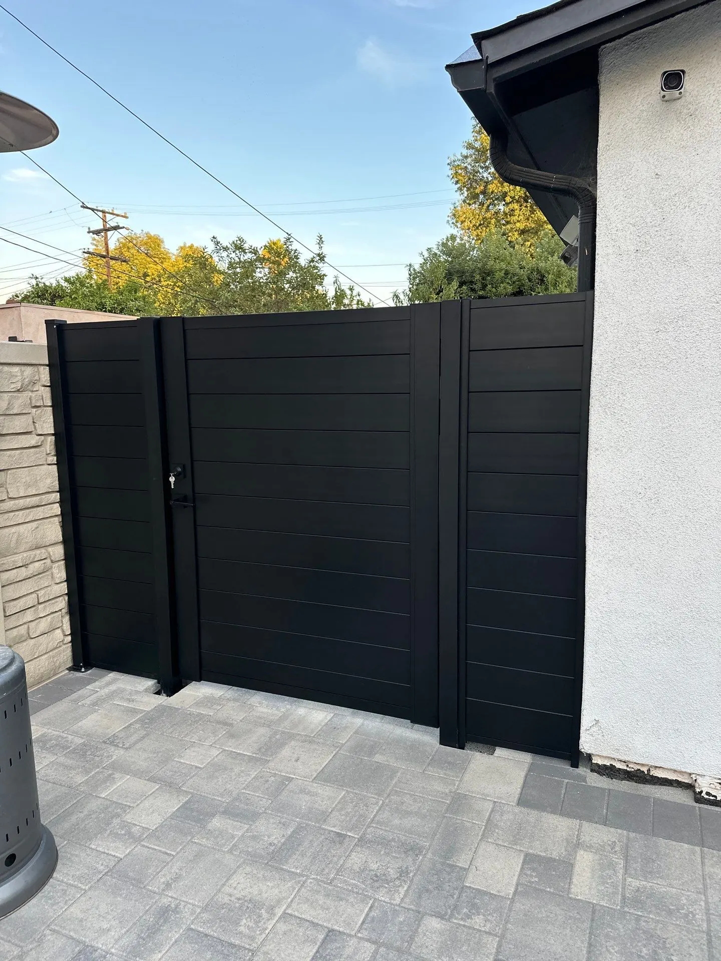 Horizontal-slat gate coordinated with fixed side panels in a residential opening