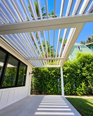 Modern white aluminum pergola roof featuring motorized adjustable louvers and integrated ceiling lights.