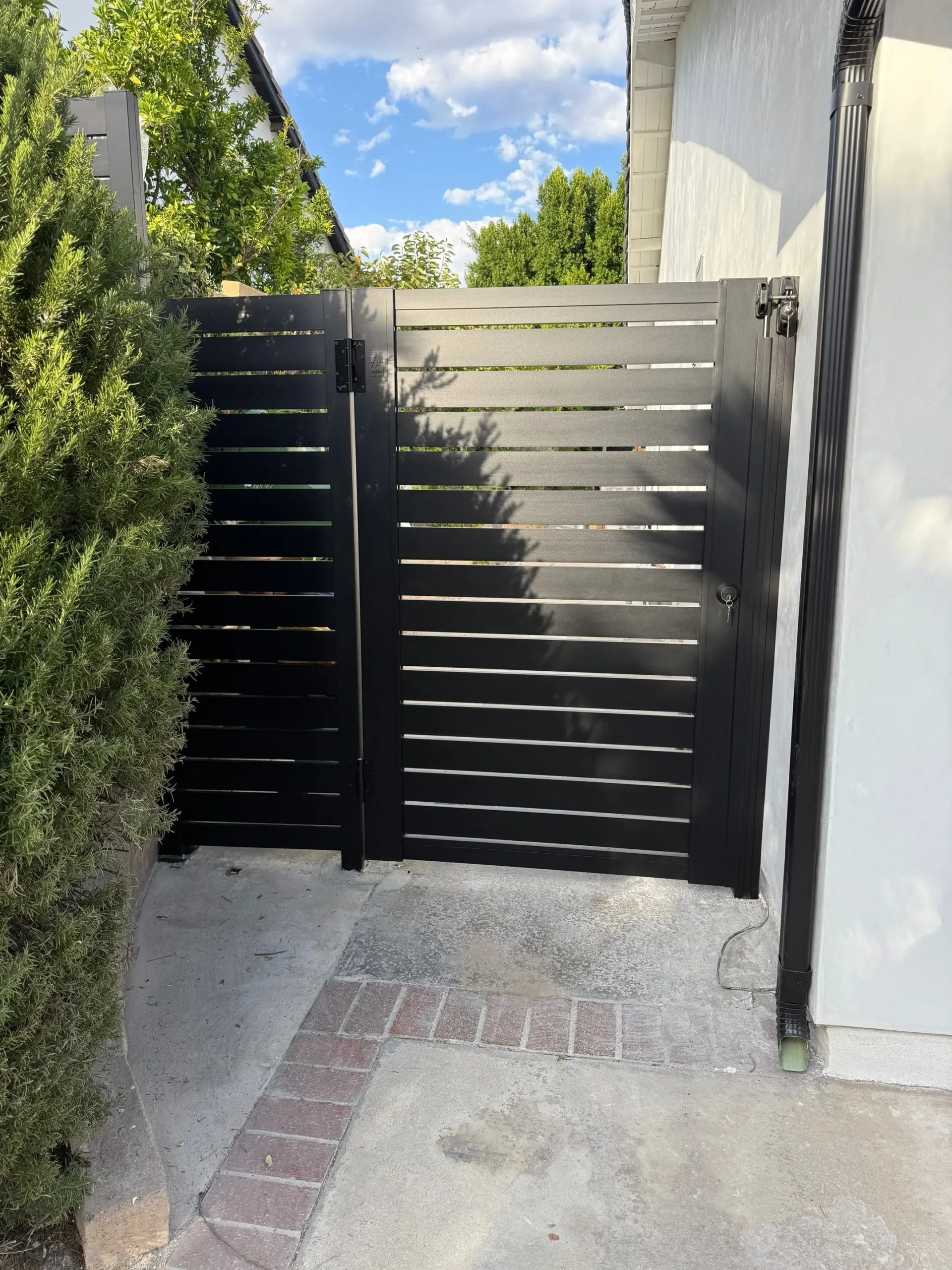 Black framed gate installed beside a house with coordinating side panel