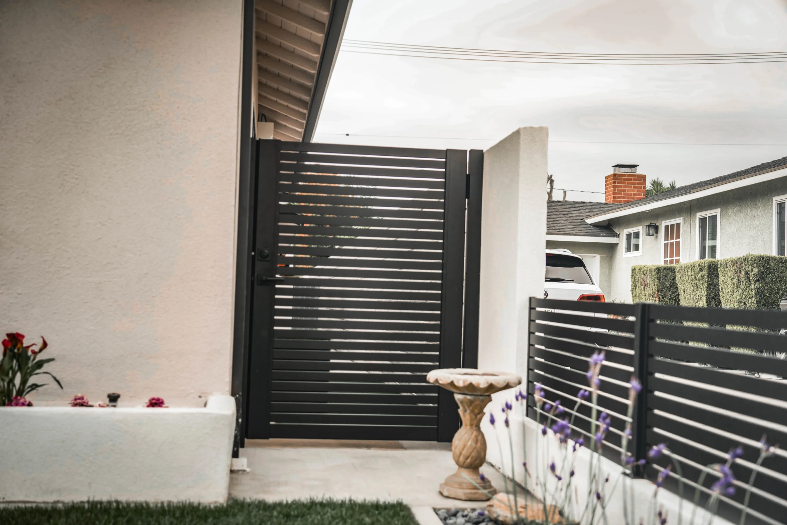 Residential aluminum entry gate coordinated with adjacent horizontal fencing