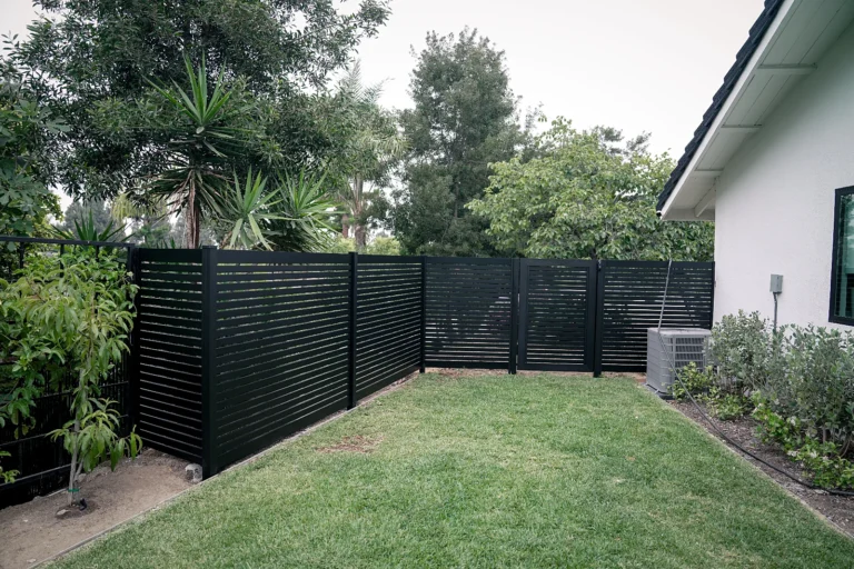 Black ALU20 horizontal slat fence around a backyard lawn