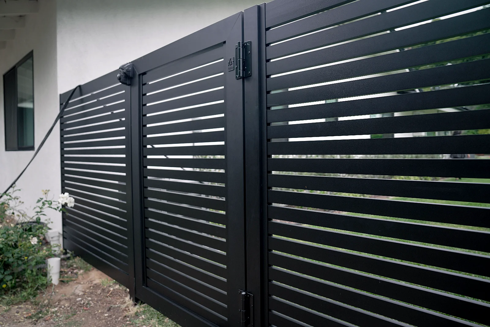 Black ALU20 fence and gate beside a modern house