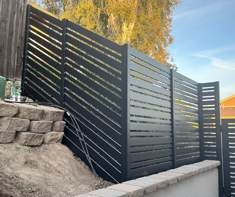 Black ALU20 fence stepping down a retaining wall