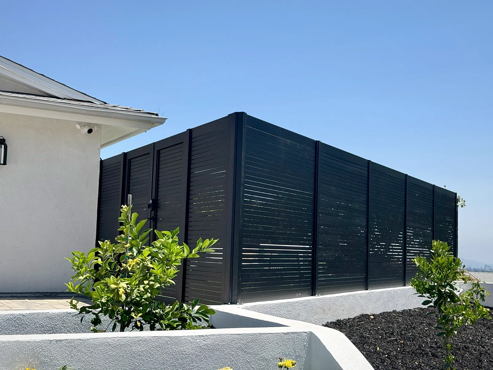 Black ALU20 privacy fence enclosing a side yard