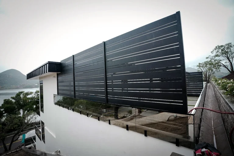 Tall black ALU20 privacy screen beside a white house