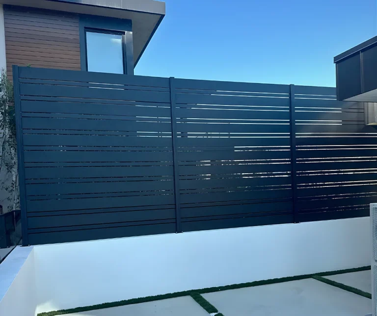 Black ALU20 fence on a white courtyard wall