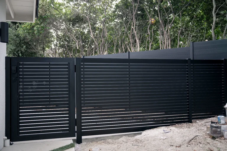 Black ALU20 slat fence with a matching gate in a backyard