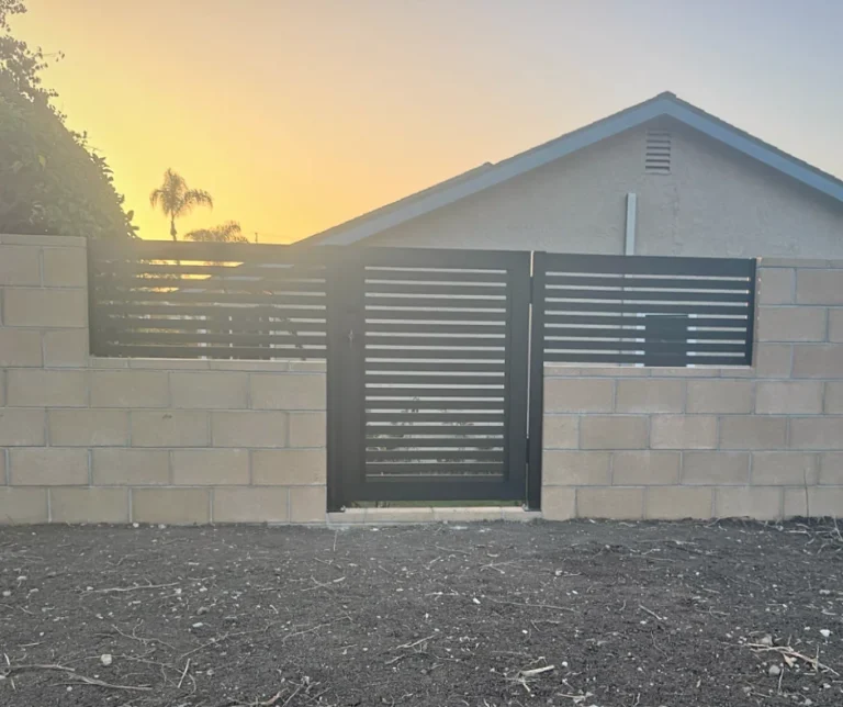 ALU20 black gate set into a block wall