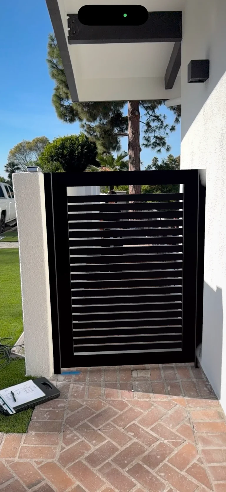 ALU20 black gate over a brick path