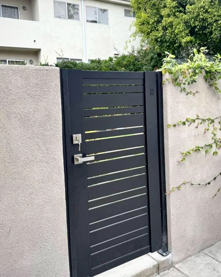 ALU20 black gate with keyed lever between stucco walls