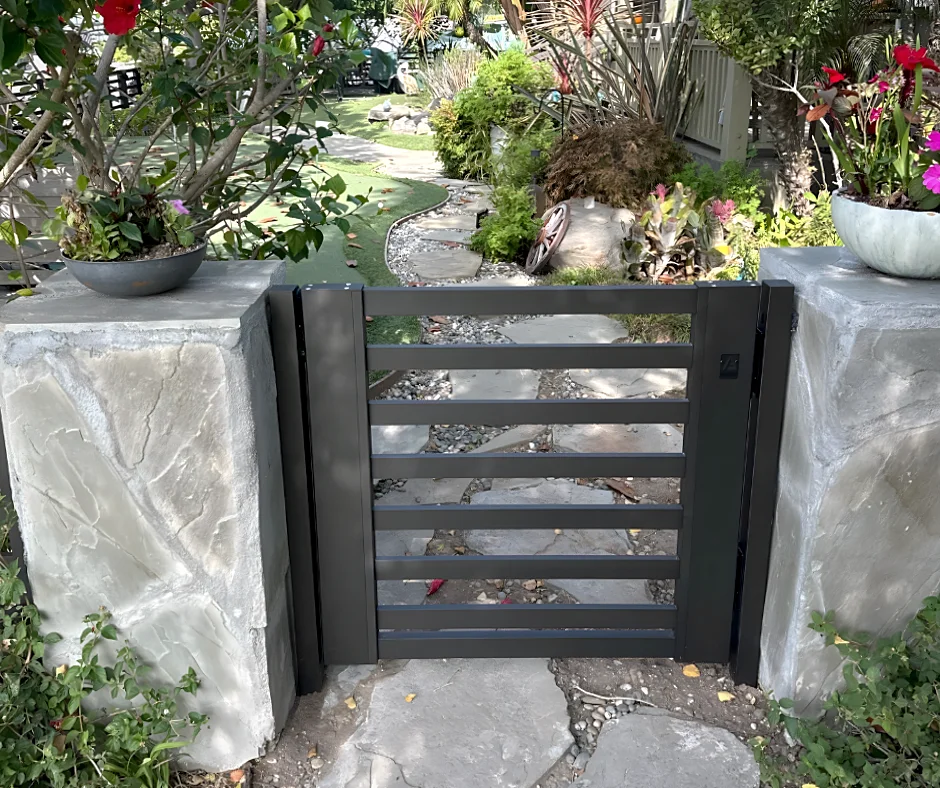 ALU20 black gate between stone pillars in a garden