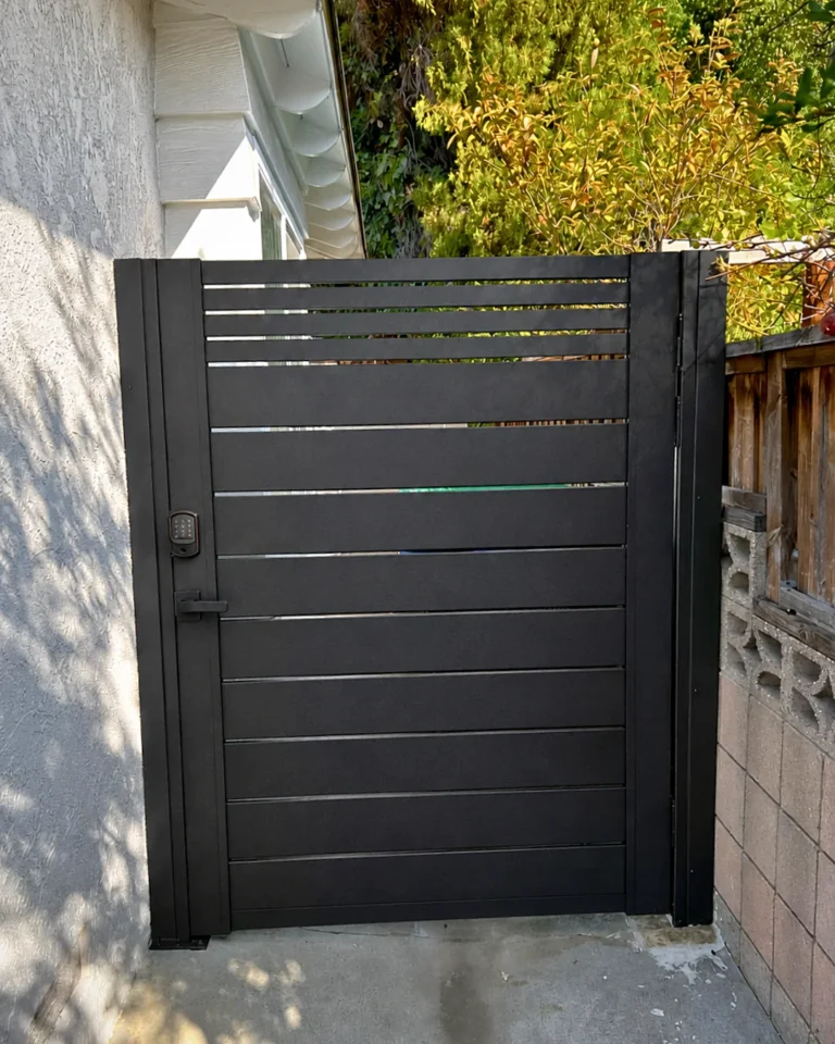 ALU20 black gate next to a wood fence