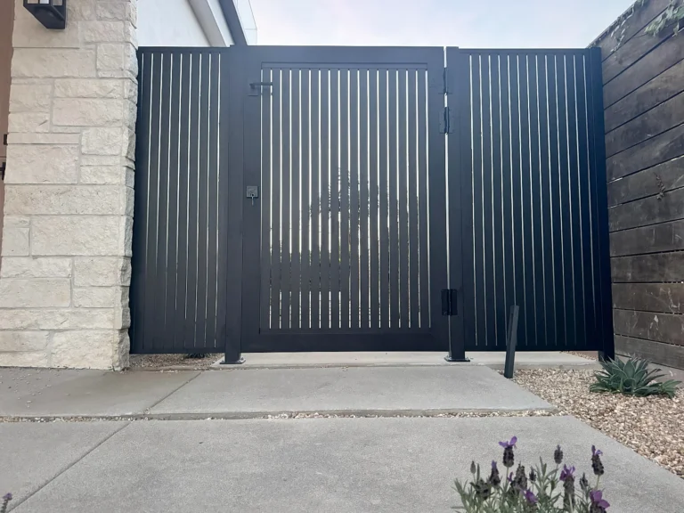 ALU20 vertical slat black gate beside a stone facade