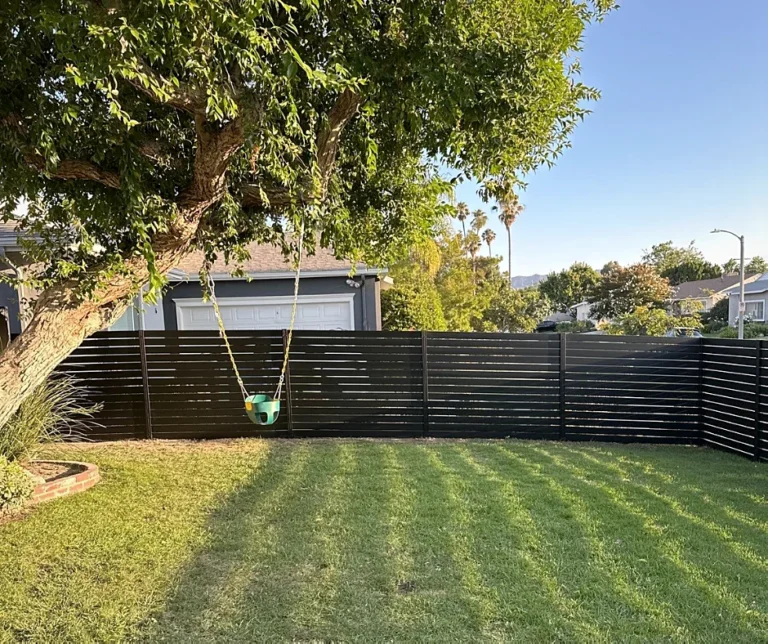 Black ALU40 fence around a backyard lawn
