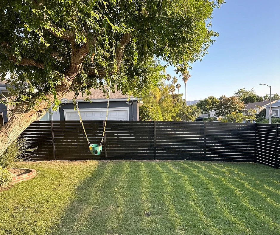 Black ALU40 fence around a backyard lawn