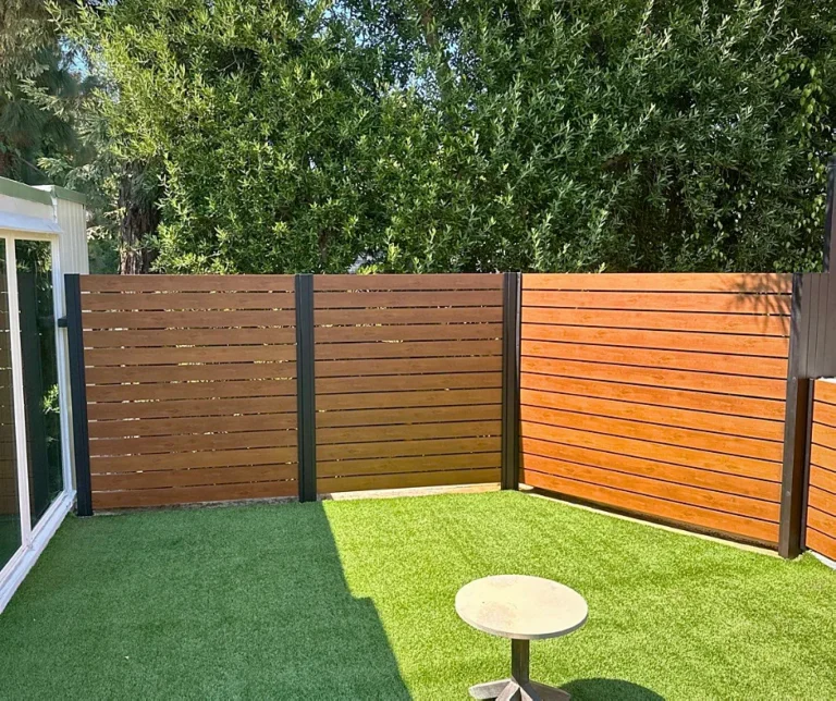 Wood grain ALU40 fence around a backyard lawn