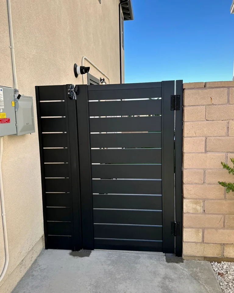 ALU40 black gate beside a block wall