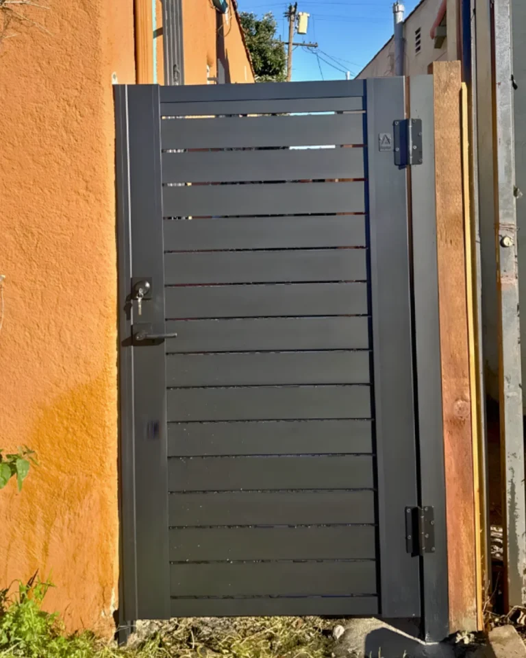 ALU40 black gate against orange stucco
