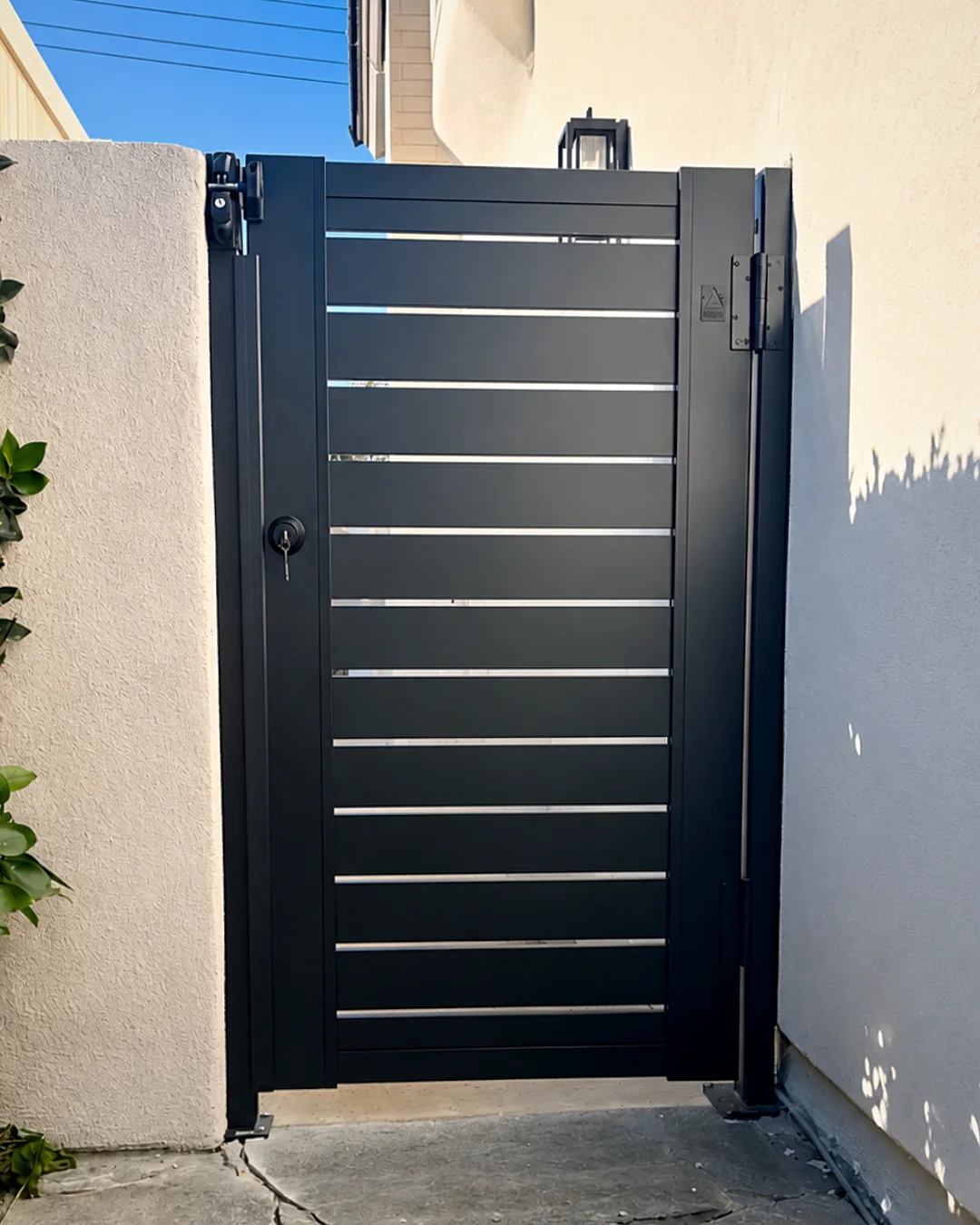 ALU40 black gate in a stucco side yard