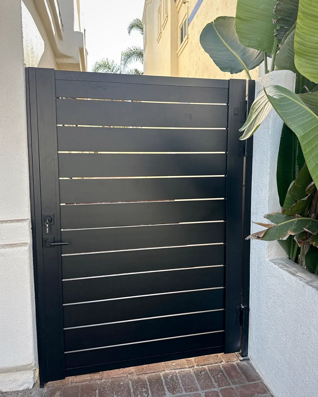 ALU40 black gate at a tropical garden entry
