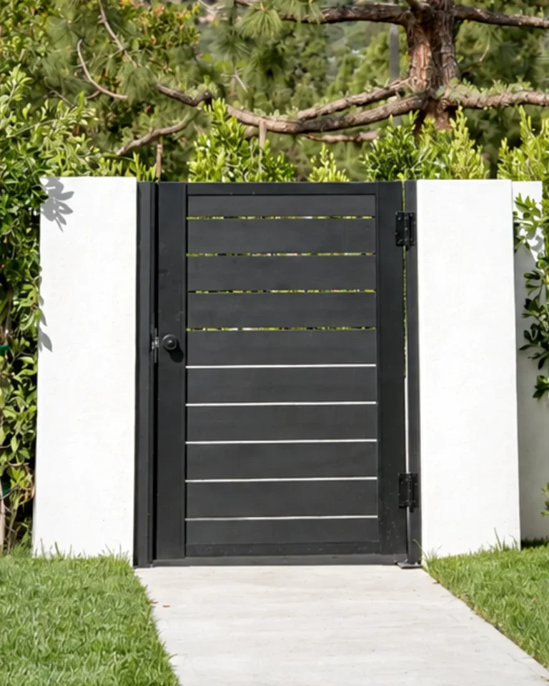 ALU40 black slat gate between white pillars on a walkway